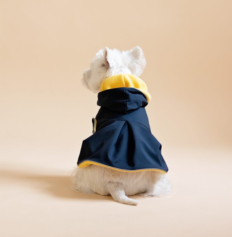 White dog sitting on fur chair wearing Waterproof Dog Coat-Dress With Plaid Hood or Collar